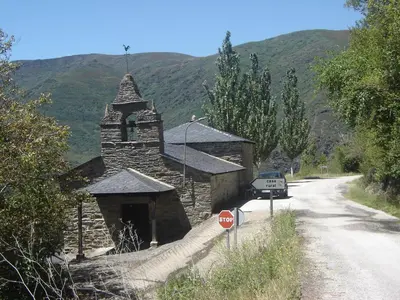 a small stone church with a stop sign next to a road at Carriles Romanos in Odollo