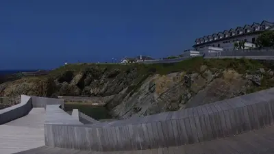 a building on top of a hill next to the ocean at Apartamentos Casa Germana in Tapia de Casariego
