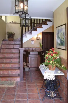 a lobby with a staircase and a table with flowers at Apartamentos Casa Germana in Tapia de Casariego
