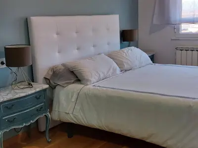 a bedroom with a large bed with a white headboard at Cozy Apartment Ponferrada 109 m², Parking in Ponferrada