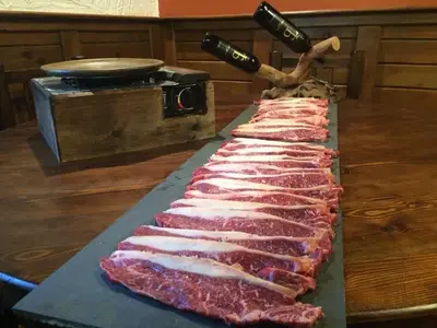 a row of meat on a cutting board with a knife at H Rural Chamouco in Bóveda