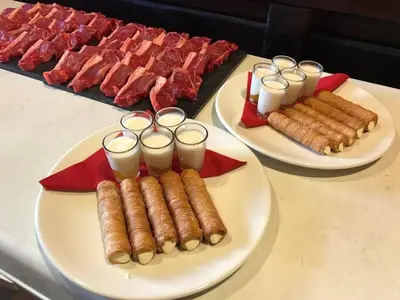 two plates of hot dogs and meat on a table at H Rural Chamouco in Bóveda