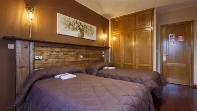 a hotel room with two beds in a bedroom at H Rural Chamouco in Bóveda