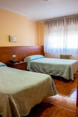 a hotel room with two beds and a window at Hotel Mabú in Ourense