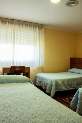 a bedroom with two beds and a window at Hotel Mabú in Ourense