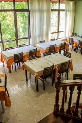 a large room with tables and chairs and windows at Hotel Mabú in Ourense