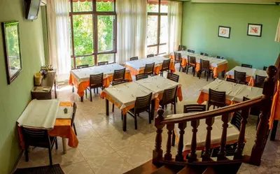 a dining room with tables and chairs and windows at Hotel Mabú in Ourense