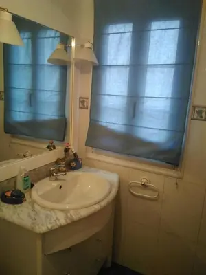 a bathroom with a sink and a window with blue blinds at Casa Laguiñas en Castro Caldelas in Castro Caldelas