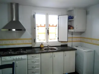 a kitchen with a sink and a stove and a window at Casa Laguiñas en Castro Caldelas in Castro Caldelas