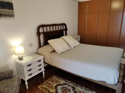 a bedroom with a bed and a dresser and a chair at Casa Laguiñas en Castro Caldelas in Castro Caldelas