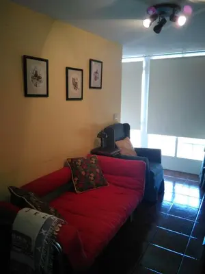 a living room with a red couch and a window at Casa Laguiñas en Castro Caldelas in Castro Caldelas