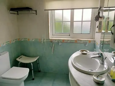 a bathroom with a sink and a toilet and a window at O Seixo 1 in Mugardos