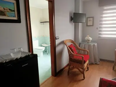 a room with a chair and a table and a mirror at O Seixo 1 in Mugardos