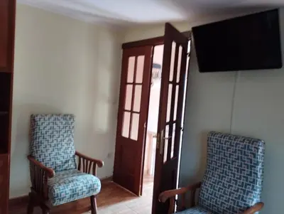 two chairs sitting in a room with a television at O Seixo 1 in Mugardos