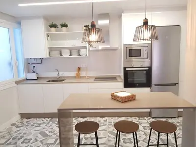 a kitchen with a table and two stools at QUATRE CASAS in Ourense
