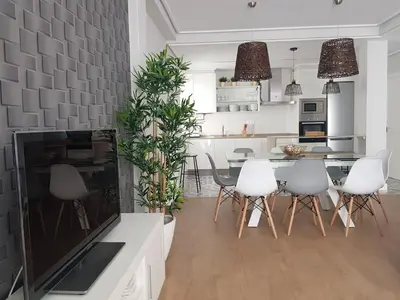 a kitchen and dining room with white chairs and a large television at QUATRE CASAS in Ourense