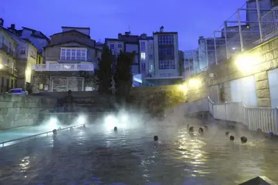 a group of people in a swimming pool at night at QUATRE CASAS in Ourense