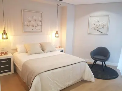 a bedroom with a bed and a chair in it at QUATRE CASAS in Ourense