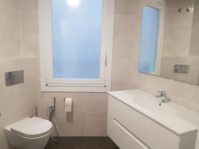 a bathroom with a toilet and a sink and a window at QUATRE CASAS in Ourense