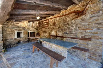 a stone wall with a bench in a room at Apartamentos A Casa Nova in A Pontenova