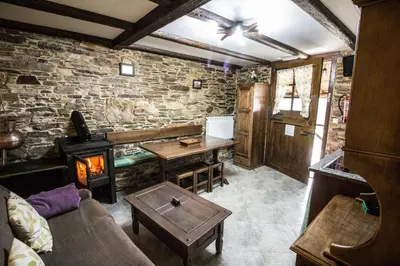 a living room with a stone wall and a fireplace at Apartamentos A Casa Nova in A Pontenova