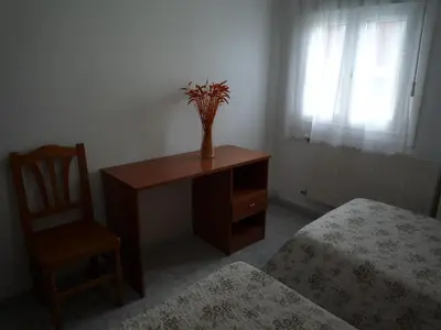 a room with a desk and a chair with a vase on it at Hostal Residencia Ponte Vella in Lugo