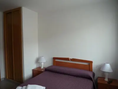 a bedroom with a bed with purple sheets and two lamps at Hostal Residencia Ponte Vella in Lugo