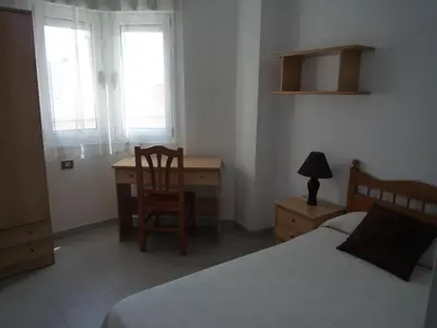 a bedroom with a desk and a bed and a chair at Hostal Residencia Ponte Vella in Lugo