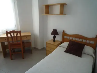 a bedroom with a bed and a desk and a chair at Hostal Residencia Ponte Vella in Lugo