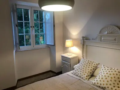 a bedroom with a bed with a lamp and a window at Oktheway Casa da Escola in Sarria