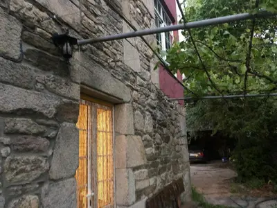 a window of a stone building with a curtain on it at Oktheway Casa da Escola in Sarria