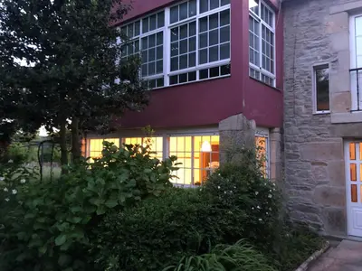 a house with lights in the window of it at Oktheway Casa da Escola in Sarria