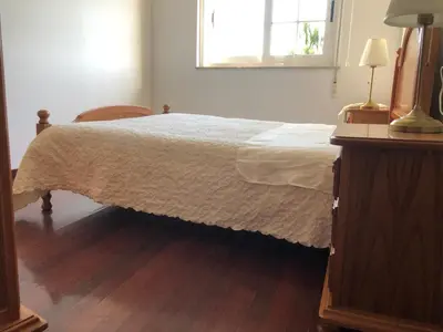 a bedroom with a bed with a wooden floor and a window at Oktheway Casa da Escola in Sarria