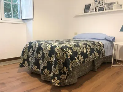 a bedroom with a bed with a black and white blanket at Oktheway Casa da Escola in Sarria