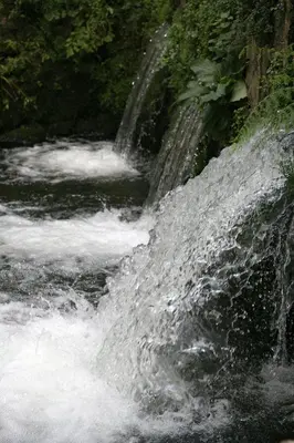 a stream of water rushing over a waterfall at Aires do Umia in Caldas de Reis