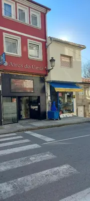 a building on a street corner with a store at Aires do Umia in Caldas de Reis