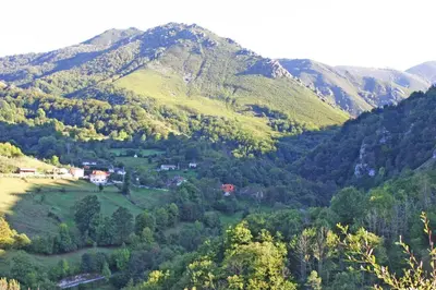a small village in a valley in the mountains at Apartamentos Valdecarzana Senda del Oso in San Martín