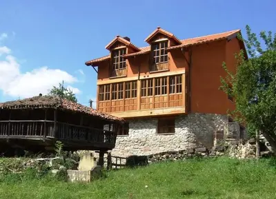 a large house on top of a hill at Apartamentos Valdecarzana Senda del Oso in San Martín