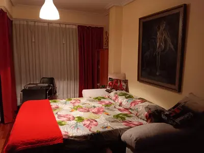 a bedroom with a bed with a flowered blanket at Piso zona Campus-Lagunas in Ourense