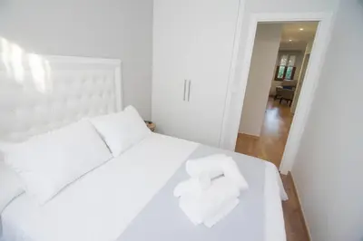 a white bed with two white towels on it at Alojamientos MYL in Arzúa