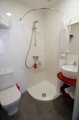 a white bathroom with a toilet and a sink at Alojamientos MYL in Arzúa