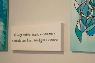a sign on a wall next to two paintings at Alojamientos MYL in Arzúa