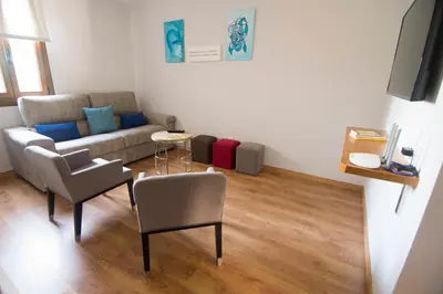 a living room with a couch and a chair at Alojamientos MYL in Arzúa