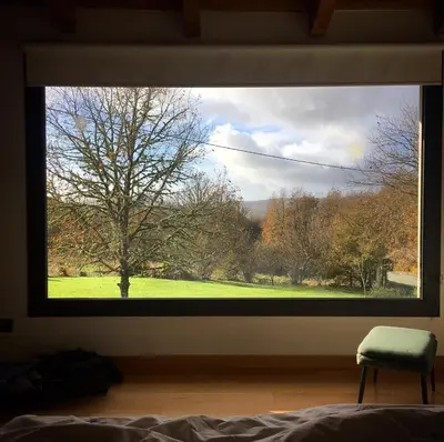 a bedroom window with a view of a green field at TOURON Nº1 in Carballedo