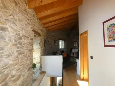 a room with a stone wall and wooden ceilings at TOURON Nº1 in Carballedo