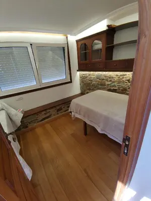 a bedroom with a bed and a stone wall at Casa Lolola in Sada