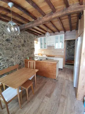 a kitchen with a wooden table and a wooden floor at Casa Lolola in Sada