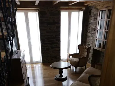 a living room with a table and chairs and windows at Casa Lolola in Sada