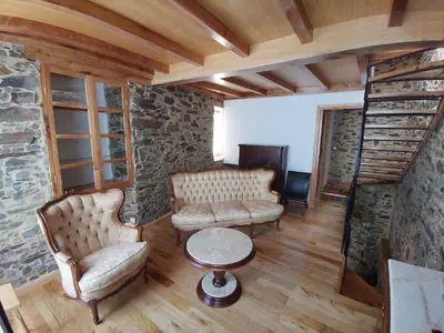 a living room with furniture and a stone wall at Casa Lolola in Sada