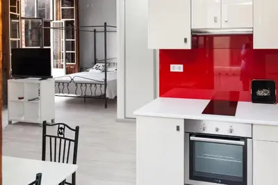 a kitchen with red and white cabinets and a dining room at Vintage Ribadavia in Ribadavia